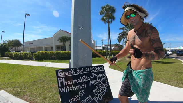 holding vaccine truth signs on side of road