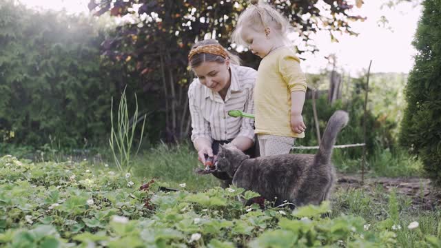 sharing with her cat her first lesson of planting