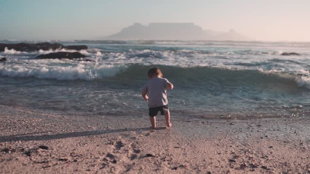The waves of the sea pull the little boy and his mother rescues him