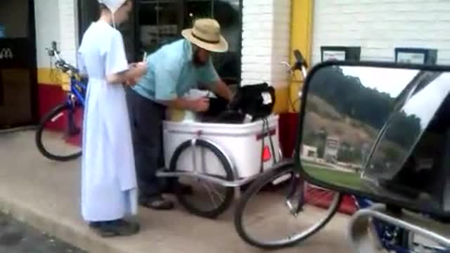 Amish at McDonald's with baby in cart behind a bike