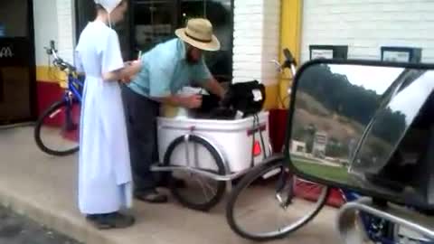 Amish at McDonald's with baby in cart behind a bike