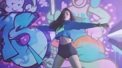 Urban dancer girl in front of a wall with graffiti