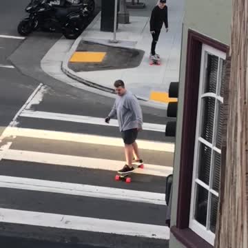 Big guy grey shirt skateboards across street crossing walk