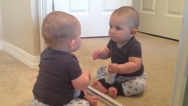 Baby scared after seeing his image in mirror