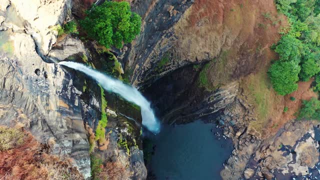 A Waterfall Cascading On A Mountain Cliff