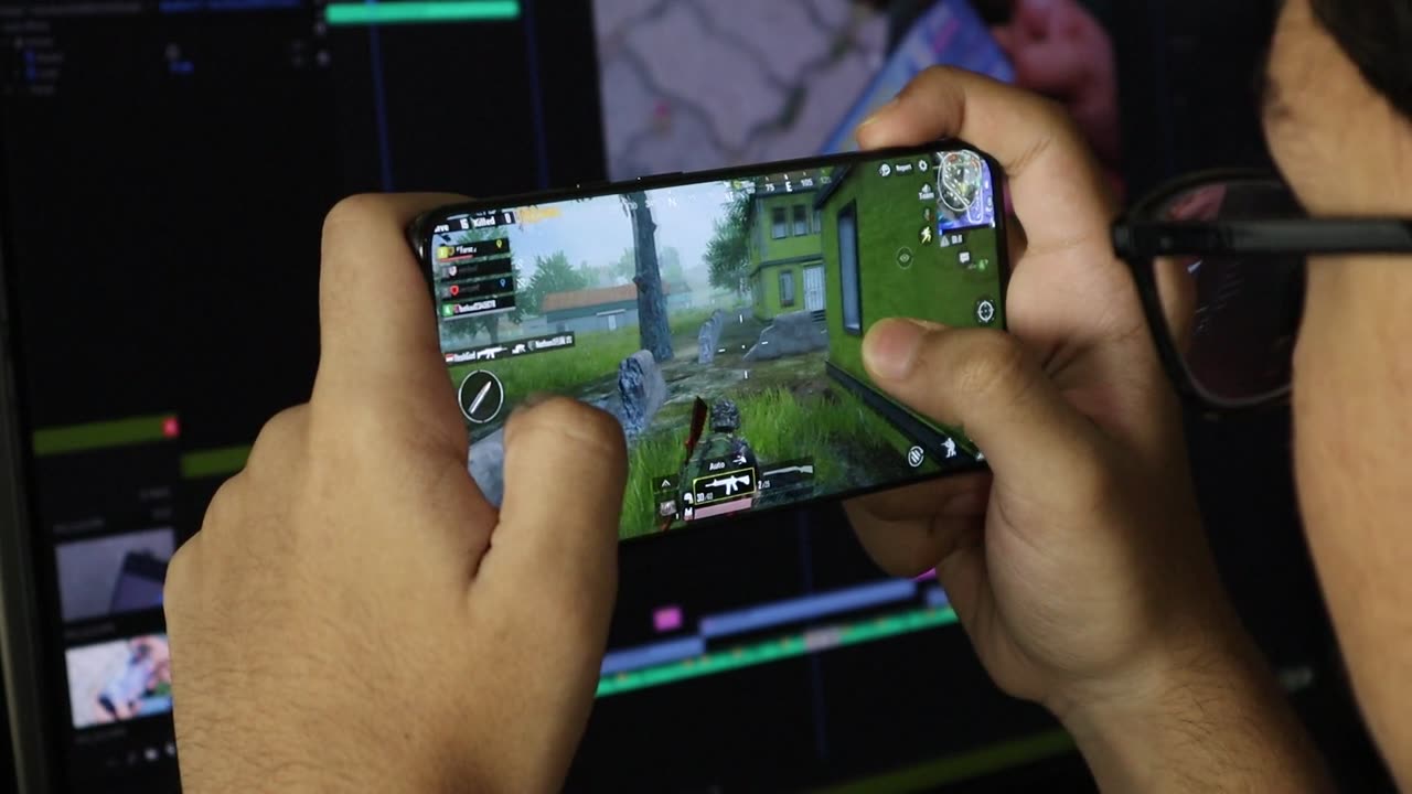 A Young Man Playing A Mobile Game