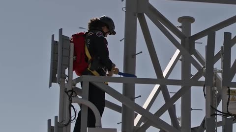 Fire brigade rescues man standing on electricity pylon