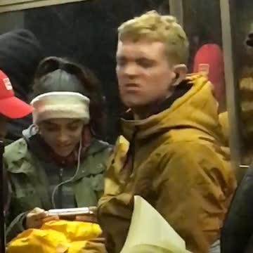 Man in yellow jacket dancing to ear phone music