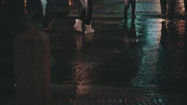 People crossing the street in the rain in a city