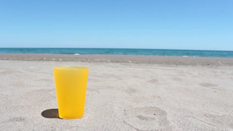 Pouring water in a glass on a sunny beach