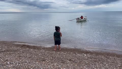 Small boy, boat and the sea