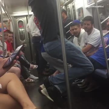 Two guys hanging from subway rail in train
