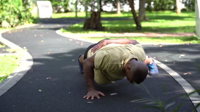 Shallow Focus of Man in Yellow Shirt Doing One-Arm Push-Ups