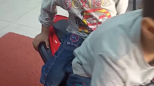 Little kids playing motor bike