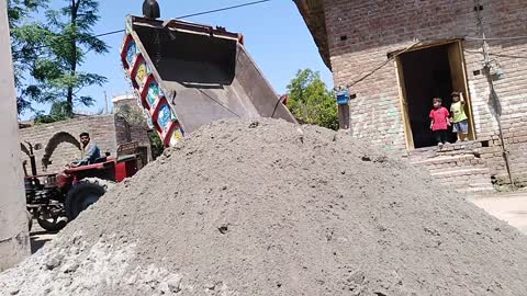 After unloading sand the tractor is going on in the way