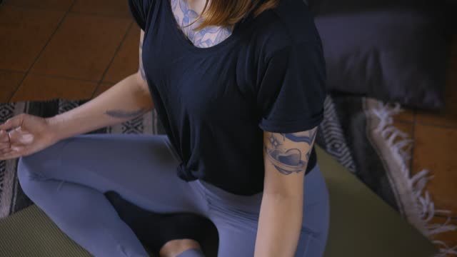 Girl meditating in yoga pose on the floor of her house