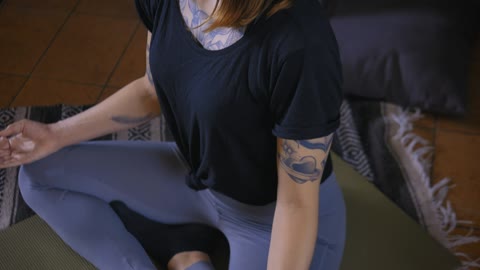 Girl meditating in yoga pose on the floor of her house