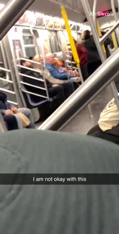 Man has a chucky doll sitting on his lap on subway train
