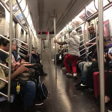 Man in red pants dances on subway train