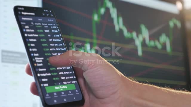 Hand Touching Display of Stock Market Quotes on Smartphone. Online Trading