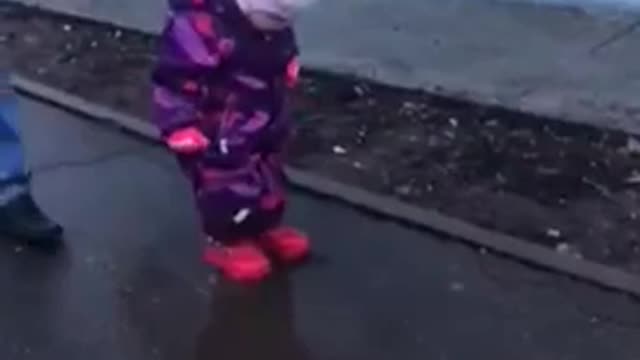 a child plays in a puddle