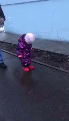 a child plays in a puddle