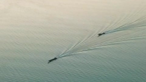 Two speedboats on a lake seen from the air