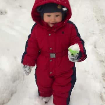A small child walks in the snow in winter