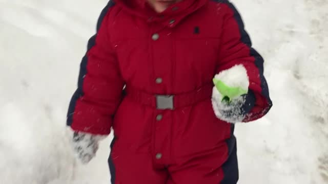 A small child walks in the snow in winter