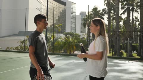 Man and woman talking after a tennis match