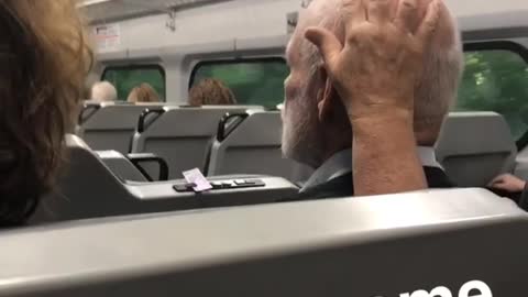 Woman rubs head of old man sitting next to her