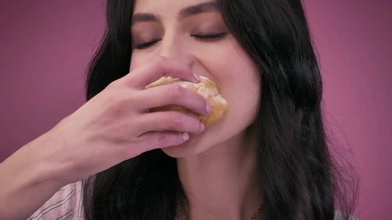 Young woman giving a big bite a donut