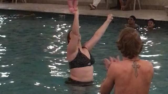 Baby Balances on Mom's Hand in Pool