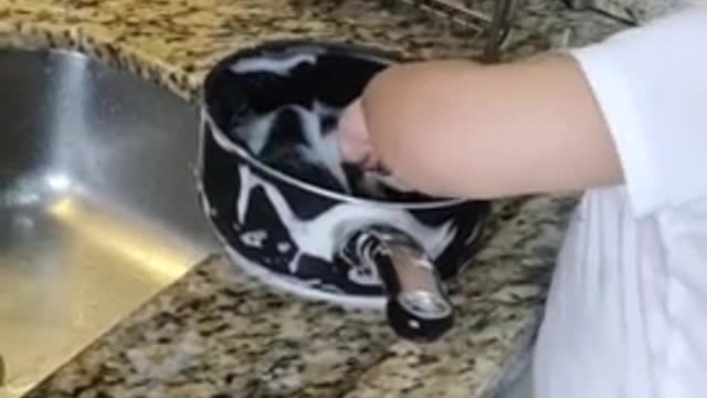 Helpful baby assists mom with the dishes