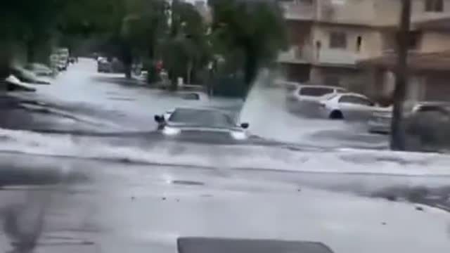 Car driving across waterlogged road