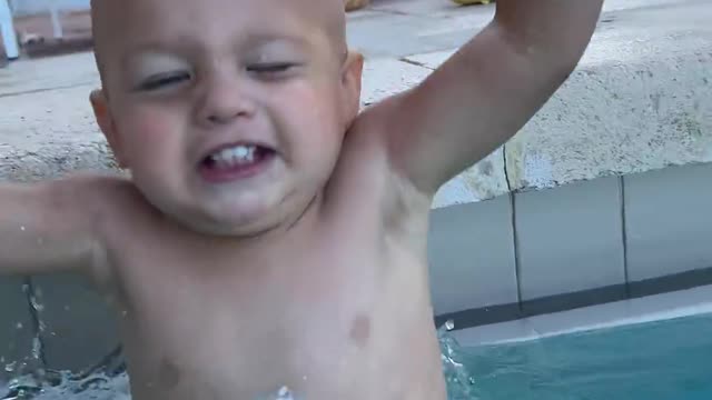 Funny baby is diving in pool