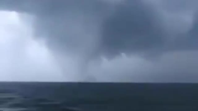 A huge waterspout was spotted, accompanied by dark clouds, as it churned over the Baltic Sea.