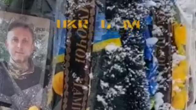 Ukraine mass grave for fallen soldiers (Bandera and Ukraine flags)