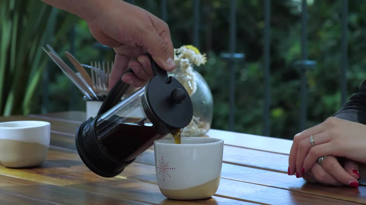 A waiter serves coffee to a customer