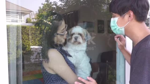 Asian couple visiting through the window at home in Coronavirus situation