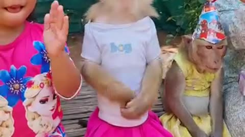 Little girl sings and dances with monkey