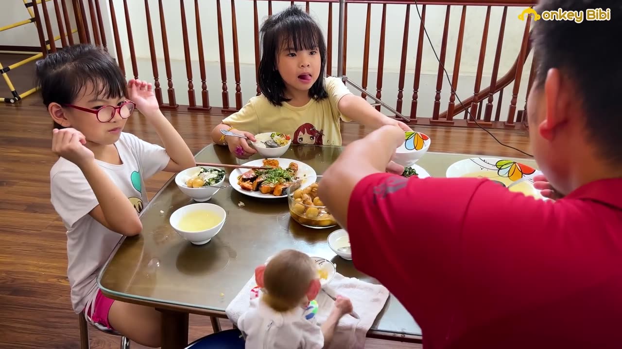 Super cute monkey eating with family member