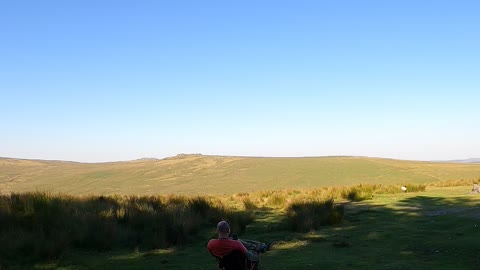 Sitting in the shade on a hot day overlooking beardown Tor. Dartmoor. Time lapse