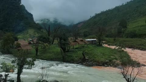 The house is built on the side of a hill overlooking the river.