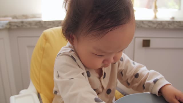 Asian Kid on his High Chair Playing with Chopped Fruits