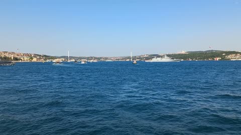 A beautiful view of the sea with the bridge in the distance and the ship being prepared for sailing