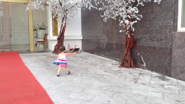 Little girl adorably chases paper in high wind gusts