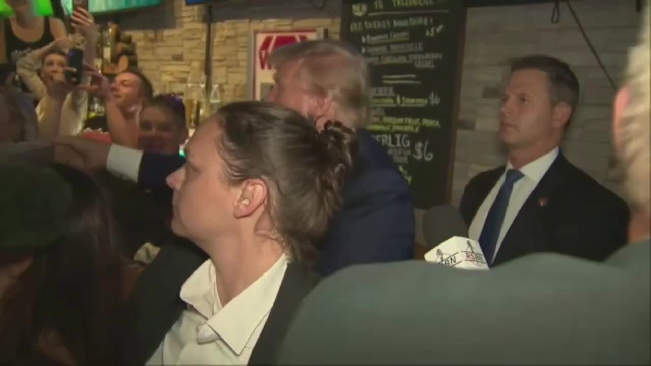 Donald Trump gets swarmed as he hands out pizza at Iowa pub