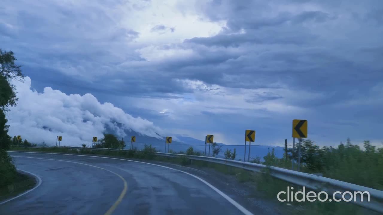 going down a curved highway through a mountain range