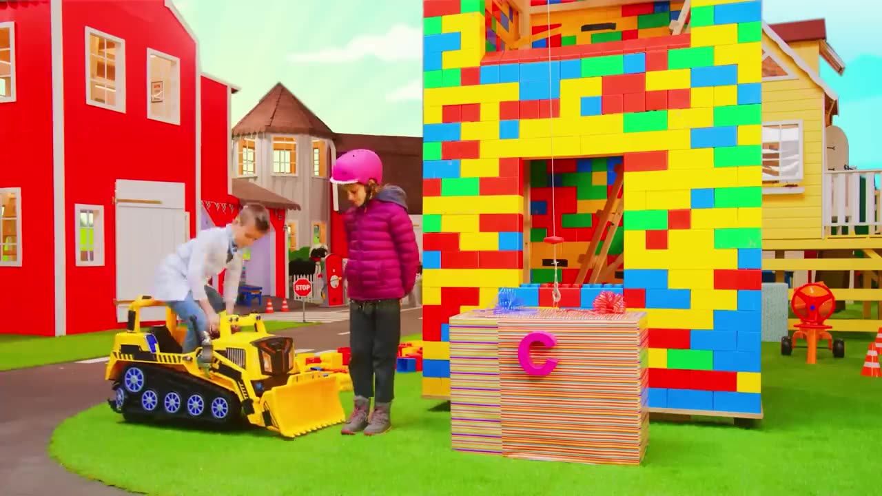 The kids build a Lego tower with a real construction vehicle